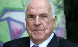 Helmut Kohl pose sur fond d'un élément du mur de Berlin dans son jardin à Oggersheim, en Allemagne, le 16 mai 2014
