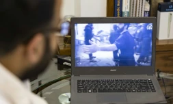 Le chirurgien orthopédique Mohammed al-Hanash regarde, le 21 décembre 2024, dans une clinique à Douma, une vidéo d'avril 2018 montrant Mouwafaq Nisrine, infirmier à l'époque, apportant les premiers soins d'urgence à une victime lors d'une attaque à Douma, en Syrie