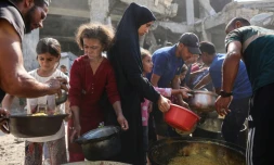 Des Palestiniens dĂ©placĂ©s attendent de recevoir de la nourriture Ă l'extĂ©rieur de la mosquĂ©e Imam al Shafi'i en ruines, oĂč des familles ont trouvĂ© refuge, dans le quartier de Zeitoun Ă Gaza, le 23 octobre 2025