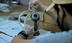 Un bénévole fabrique des visières de protection contre le Covid-19 pour les offrir aux médecins dans un ancien atelier de couture, le 28 octobre 2020 à Caracas, au Venezuela