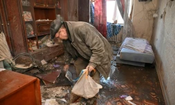 Un homme cherche des effets personnels dans on appartement détruit, dans les faubourgs de Kharkiv, dans l'est de l'Ukraine, le 20 avril 2022