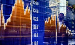 Des piétons passent devant les variations de la Bourse de Tokyo, le 6 novembre 2020