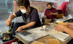 Jung Jung-soon (G) et son mari Lim Chang-joo confectionnent leurs "dalgonas", friandise rendue célèbre par la série Squid Game, à Séoul le 10 octobre 2021