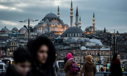 Des piétons traversent le pont de Galata à Istanbul, le 27 janvier 2018, avec la mosquée de Suleymaniye en arrière-plan
