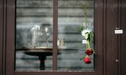 Des roses glissées dans les impacts de balle sur la vitrine de la "Bonne Bière" en hommage aux victimes, le 17 novembre 2015 à Paris