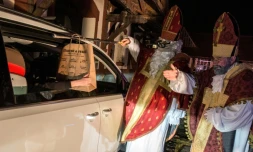 Des artistes du cirque Cirk La Putyka, déguisés en Saint Nicholas, distribuent des cadeaux aux enfants en voiture le 5 décembre 2020 à Prague