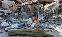 Un garçon palestinien se repose dans les décombres de Khan Younès, dans le sud de la bande de Gaza, le 10 octobre 2025.