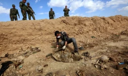 Un Iraquien inspecte les restes des corps de Yazidis tués par l'EI le 3 février 2015 au nord-ouest de l'Irak