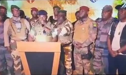 Image tirĂ©e d'une vidĂ©o prise par Gabon 24 montrant des soldats gabonais Ă la tĂ©lĂ©vision, le 30 aoĂ»t 2023, annonçant "mettre fin au rĂ©gime en place" oĂč les rĂ©sultats officiels de la prĂ©sidentielle venaient de consacrer la victoire du prĂ©sident Ali Bongo