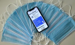 Des masques sanitaires et un carnet de vaccination affiché sur l'écran d'un téléphone portable à Montpellier le 27 janvier