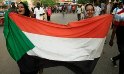 Des femmes soudanaises manifestent contre le Conseil militaire de transistion brandissant le drapeau national le 30 juin 2019 dans le centre de Khartoum
