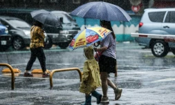 Des personnes tiennent des parapluies dans la rue sous la pluie Ă Keelung aprĂšs le passage du typhon Haikui Ă TaĂŻwan, le 4 septembre 2023