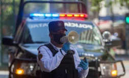 Un policier utilise un haut-parleur pour inviter les passants à rentrer chez eux, le 25 mars 2020 à Monterrey, au Mexique