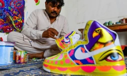 L’artiste Haider Ali peint une paire de baskets dans son studio de Karachi, le 28 fĂ©vrier 2022