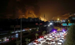 Circulation dense sur une autoroute à Téhéran alors qu'un incendie fait rage à proximité dans un dépôt de carburant, le 15 juin 2025