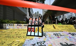 Un manifestant se tient derrière une pancarte devant le tribunal de Kowloon à Hong Kong le 1er mars 2021 