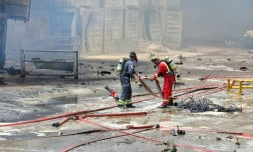 Photo fournie par le Croissant-Rouge iranien (IRCS), le 28 avril 2025, de pompiers sur les lieux d'une explosion massive deux jours plus tĂŽt dans le port Shahid RajaĂŻ, dans la province d'Hormozgan, en Iran