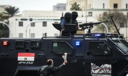 Un Egyptien tend des fleurs à des policiers des forces spéciales, sur la place Tahrir, au Caire, le 25 janvier 2016