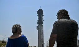 Des personnes observent la fusée Starship sur la rampe de lancement avant son quatriÚme vol d'essai à la base spatiale Starbase de SpaceX à Boca Chica, au Texas, le 5 juin 2024