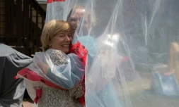 Carolyn Ellis serre sa mĂšre dans ses bras grĂące Ă un "gant Ă cĂąlin" qu'elle a mis au point avec son mari Andrew, le 16 mai 2020 Ă Guelph, dans l'Ontario