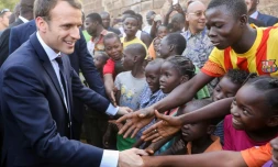 Emmanuel Macron serrant les mains d'enfants burkinabés, après la visite d'une école de Ouagadougou, le 28 novembre 2017