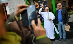 Des touristes se prennent en photo avec une statue de cire représentant le pape François à Dublin, le 24 août 2018