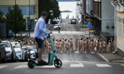 Des volontaires se déplacent nus le 15 juillet 2023 dans les rues de Kuopio, dans le centre de la Finlande, à l'initiative du photographe plasticien américain Spencer Tunick