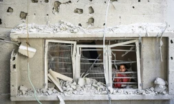 Un enfant palestinien regarde par la fenĂȘtre d'un appartement endommagĂ© par une frappe israĂ©lienne sur le camp de rĂ©fugiĂ©s de Nousseirat, dans le centre de la bande de Gaza, le 6 juillet 2024
