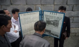 Des passants lisent un journal évoquant un tir de missile nord-coréen, le 15 mai 2017 à Pypngyang