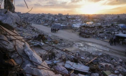 Des Palestiniens traversent à bord d'une charette une route au milieu des décombres à Beit Lahia, dans le nord de la bande de Gaza, le 4 mars 2025

