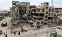 Des habitants devant un immeuble résidentiel détruit par une frappe aérienne américano-israélienne à Téhéran, le 13 avril 2026