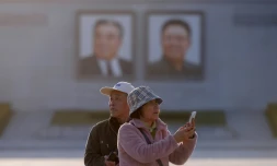 Des touristes chinois prennent des photos sur la place Kim Il Sung à Pyongyang, le 14 avril 2019 en Corée du Nord