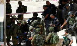 Des membres des forces de sécurité israéliennes évacuent un des Palestiniens abattus aprÚs une attaque au couteau, le 19 septembre 2016, prÚs du Tombeau des Patriarches, à Hébron