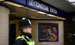 Un policier britannique surveille l'entrée du métro Leytonston au nord de Londres le 6 décembre 2015