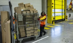 Un employé pousse un conteneur de colis dans un entrepôt DHL à Lesquin, près de Lille, le 12 novembre 2025