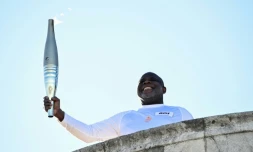 L'ancien footballeur français Basile Boli tient la flamme olympique à la basilique Notre-Dame de la Garde, à Marseille, le 9 mai 2024