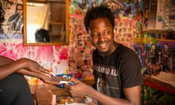 Debonheur Koli dans son échoppe avec une cliente venue pour une manucure, à Bangui le 14 juillet 2021