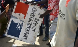 Des manifestants tiennent un panneau de l'ambassade de France aprĂšs un rassemblement en soutien aux militaires putschistes au Niger, le 30 juillet 2023 Ă Niamey