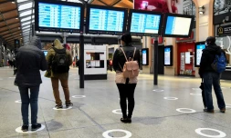 Des passagers Ă la gare Saint-Lazare Ă Paris, le 11 mai 2020 respectent les marquages au sol de distanciation sociale