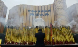 Un homme salue la statue de l'Empereur jaune le 9 avril 2016 lors d'une cérémonie à Xinzheng, en Chine