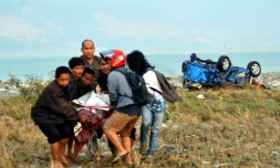Un corps porté le 29 septembre 2018 par des habitants de Palu après un fort séisme sur l'île indonésienne des Célèbes.