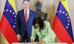 Photo diffusée par le bureau de presse de la présidence vénézuélienne montrant la présidente par intérim du Venezuela, Delcy Rodriguez (d), signant un document aux côtés du ministre américain à l'Intérieur, Doug Burgum, au palais présidentiel de Miraflores, le 5 mars 2026 à Caracas