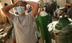 Des proches de malades du Covid-19 font la queue pour faire recharger des bouteilles d'oxygÚne à l'hÎpital d'Iquitos, au Pérou, le 14 mai 2020