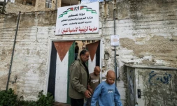 Les jumeaux Ahmad (d) et Mohammad, accompagnés par leur père Ibrahim al-Hajj, sortent de leur école à Naplouse, le 10 février 2026 en Cisjordanie occupée