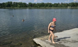 Raissa, 67 ans, sort de l'eau à Sloviansk, le 6 août 2025, dans la région de Donetsk