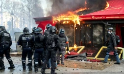 Les forces de police devant Le Fouquet's en feu, sur les Champs Elysées, à Paris, le 16 mars 2019