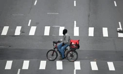 Un livreur à vélo traverse la 1re Avenue, désertée, le 17 mars 2020 à Manhattan