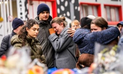 Des personnes en deuil rassemblées devant le bar Le Constellation  à Crans-Montana, en Suisse, le 2 janvier 2026, où un incendie à fait de nombreux morts et blessés durant la nuit du Nouvel An