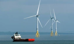 Un ferry passe à proximité d'éoliennes au large d'Aberdeen, le 29 avril 2022, dans le nord-est de l'Ecosse