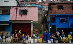 Des habitants du quartier de Petare font la queue avec des bidons et des seaux pour s'approvisionner en eau, le 1er avril 2019 à Caracas, au Venezuela